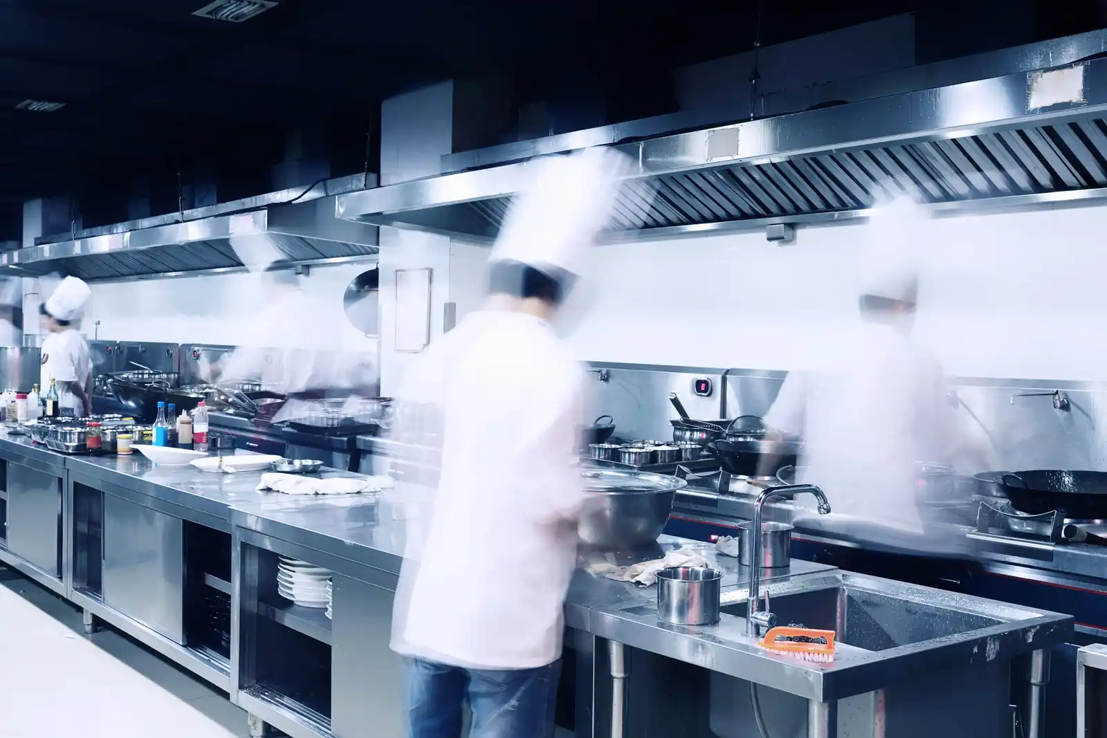 Technician cleaning a commercial kitchen canopy